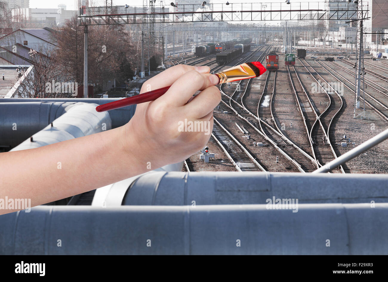Travel Concept - la main avec des peintures pinceau locomotive rouge sur railway station Banque D'Images
