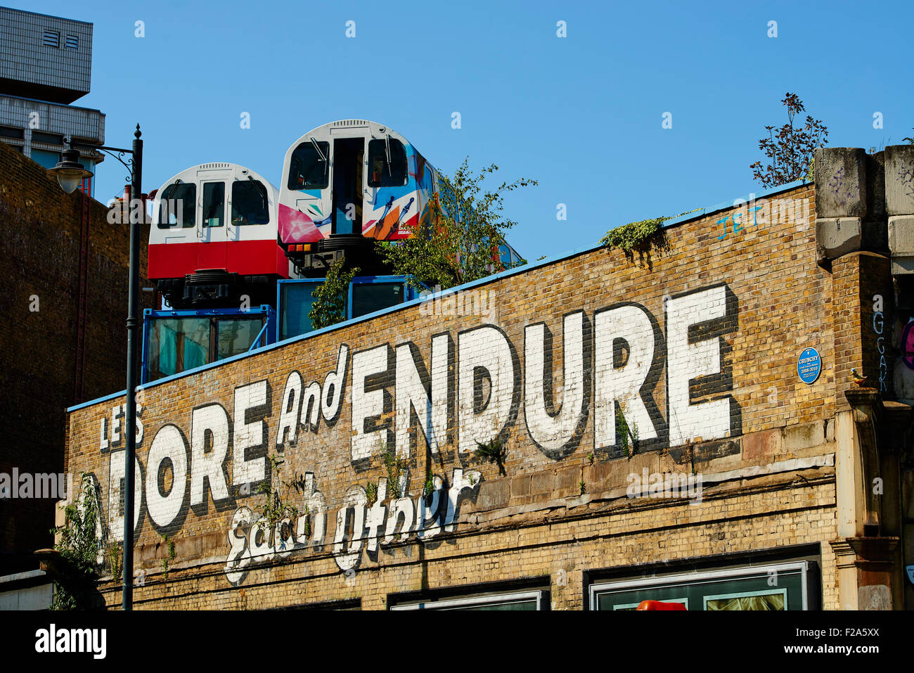 Wagons de train recyclé utilisé comme des studios au-dessus de l'ancien viaduc de chemin de fer avec des murs utilisé pour arty graffiti, London, United Kin Banque D'Images
