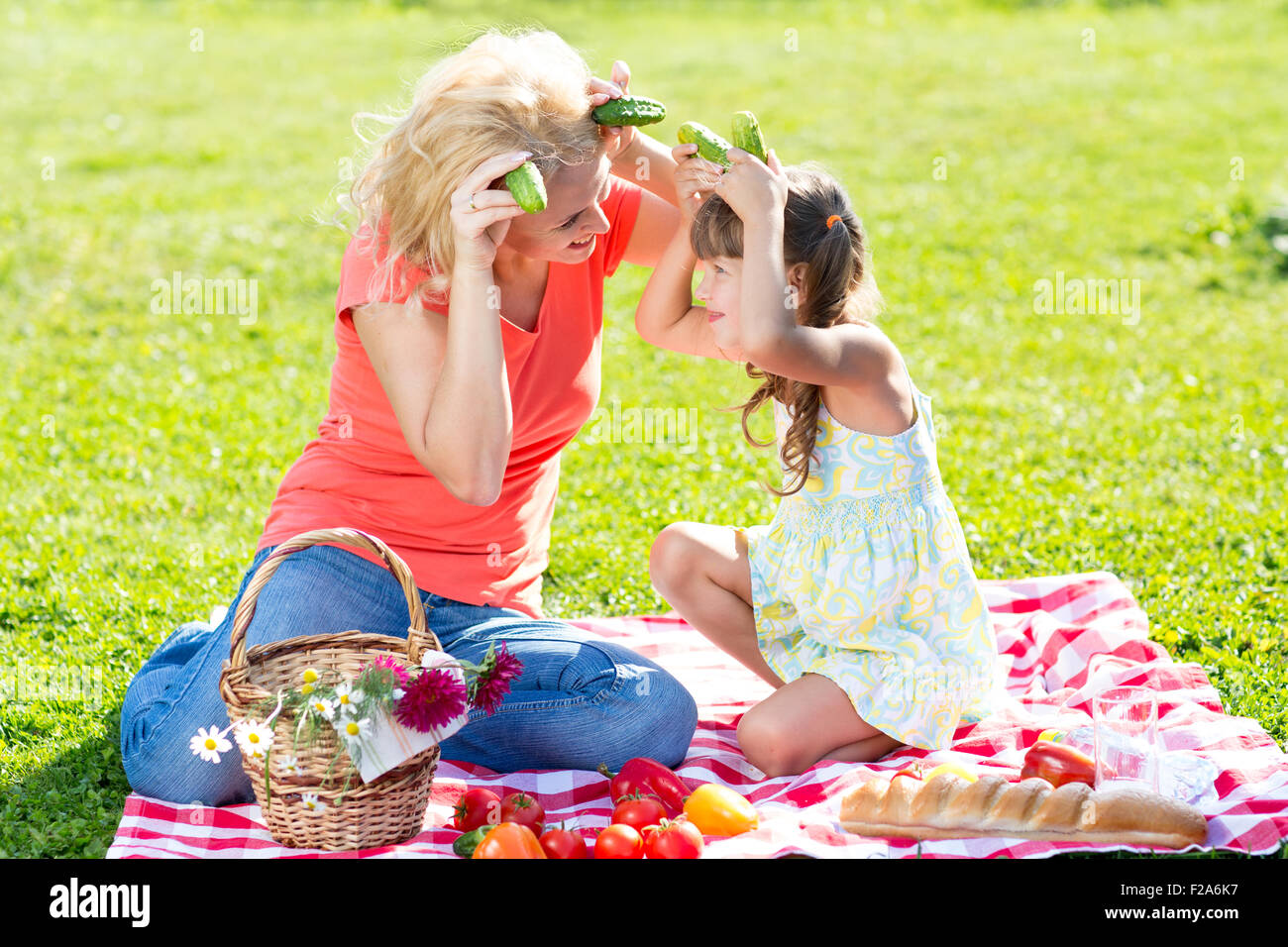 La mère et l'enfant s'amusant pique-nique sur l'herbe Banque D'Images