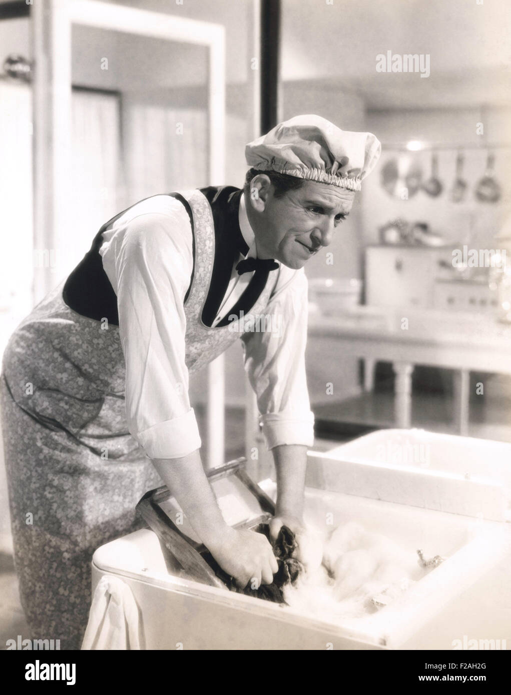 Homme laver les vêtements à l'évier de cuisine (OLVI008 OU  F054) Banque D'Images