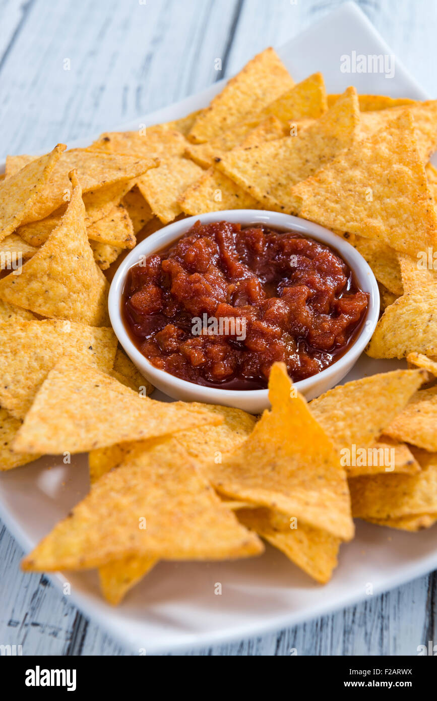 Nachos avec sauce salsa (close-up shot) sur fond de bois Banque D'Images