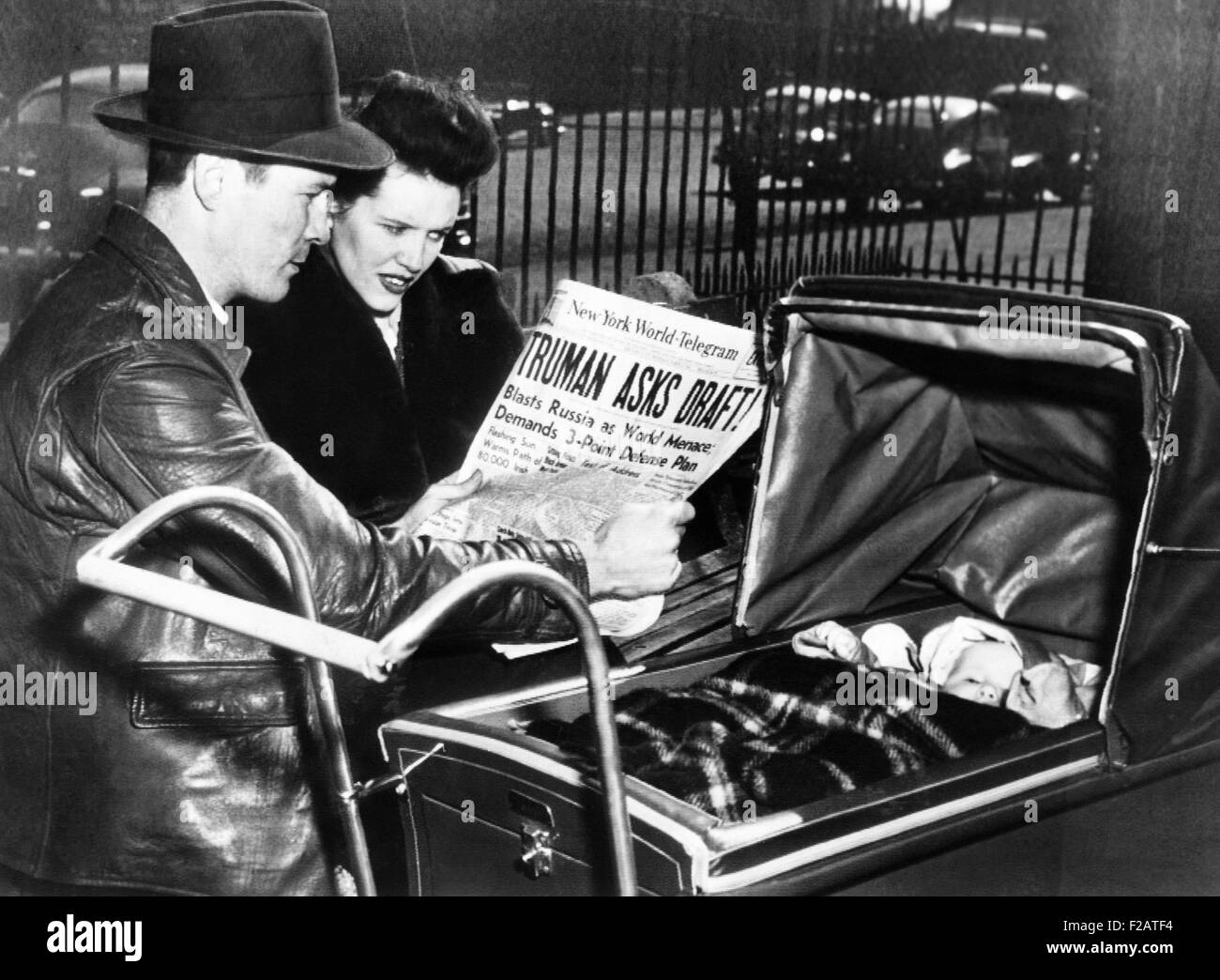 Un ancien combattant de la Seconde Guerre mondiale et sa femme, avec bébé, lisez le titre, 'Truman Demande Projet !' 17 Mars, 1948. En réponse aux tensions de la guerre froide, le président Truman a demandé au Congrès d'un projet de paix. Le 20 juillet 1948, a publié une proclamation Truman nécessitant près de 10 millions d'hommes à s'inscrire pour le service militaire possible (CSU 2015  1665 11) Banque D'Images