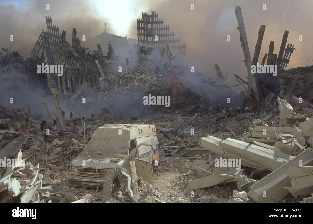Un couvertes de poussière dans les restes du World Trade Center le 13 septembre 2001. Les travailleurs d'urgence dans l'arrière-plan sont véhiculer l'ampleur de la ruine. La ville de New York, après des attaques terroristes du 11 septembre 2001. (BSLOC_2015_2_66) Banque D'Images