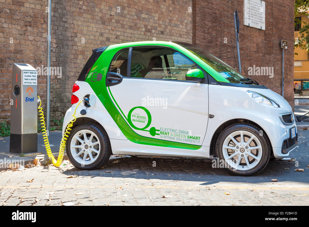 Smart fortwo electric drive voiture électrique branché à une borne de recharge pour voitures électriques dans Rome Roma Lazio Italie Europe de l'UE Banque D'Images