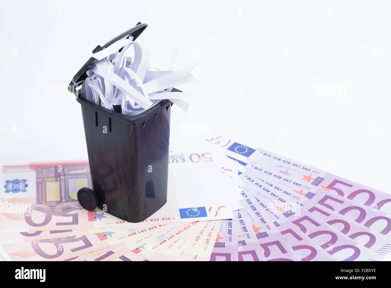 Image montre une poubelle avec de l'argent sur blanc Banque D'Images