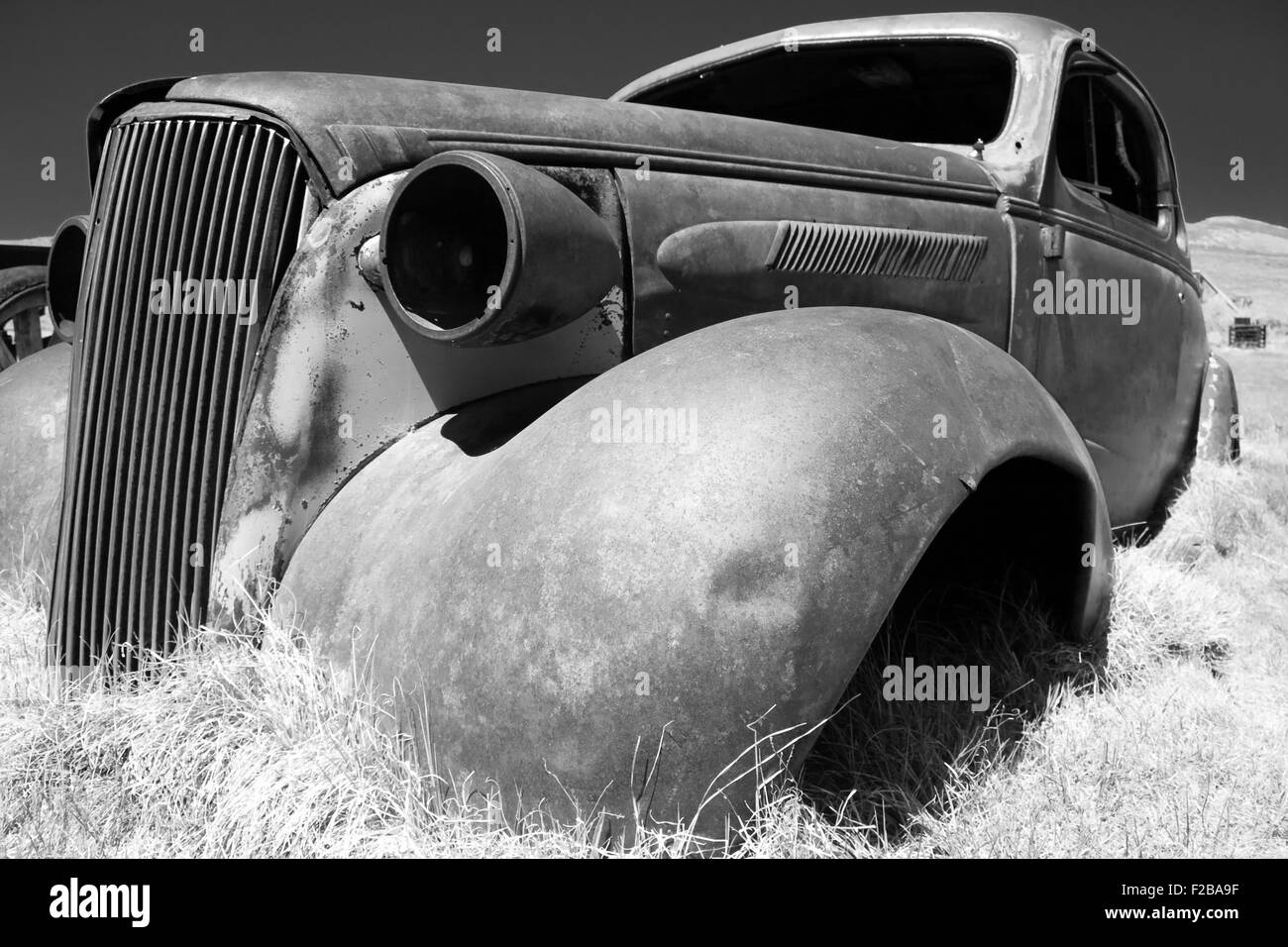 Coquille de grande voiture américaine de rouille sur terrain accidenté dans l'historique parc Bodie, en Californie. Banque D'Images
