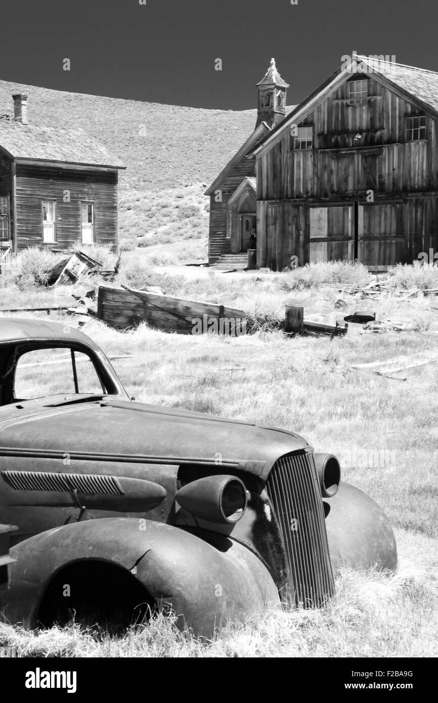 Voiture abandonnée et les bâtiments historiques en bois en Bodie State Historic Park de l'or californien une ville fantôme. Banque D'Images