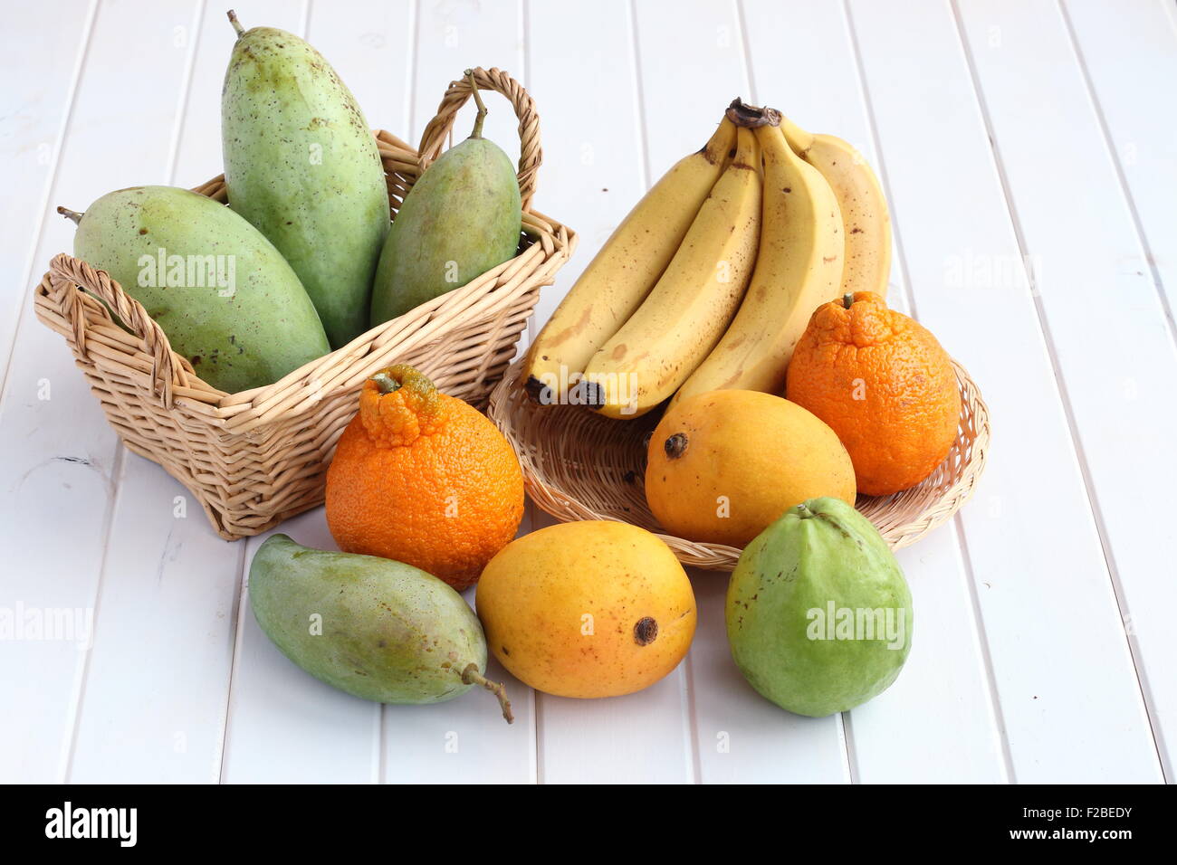 Sélection de fruits tropicaux sur planche de bois blanc Banque D'Images