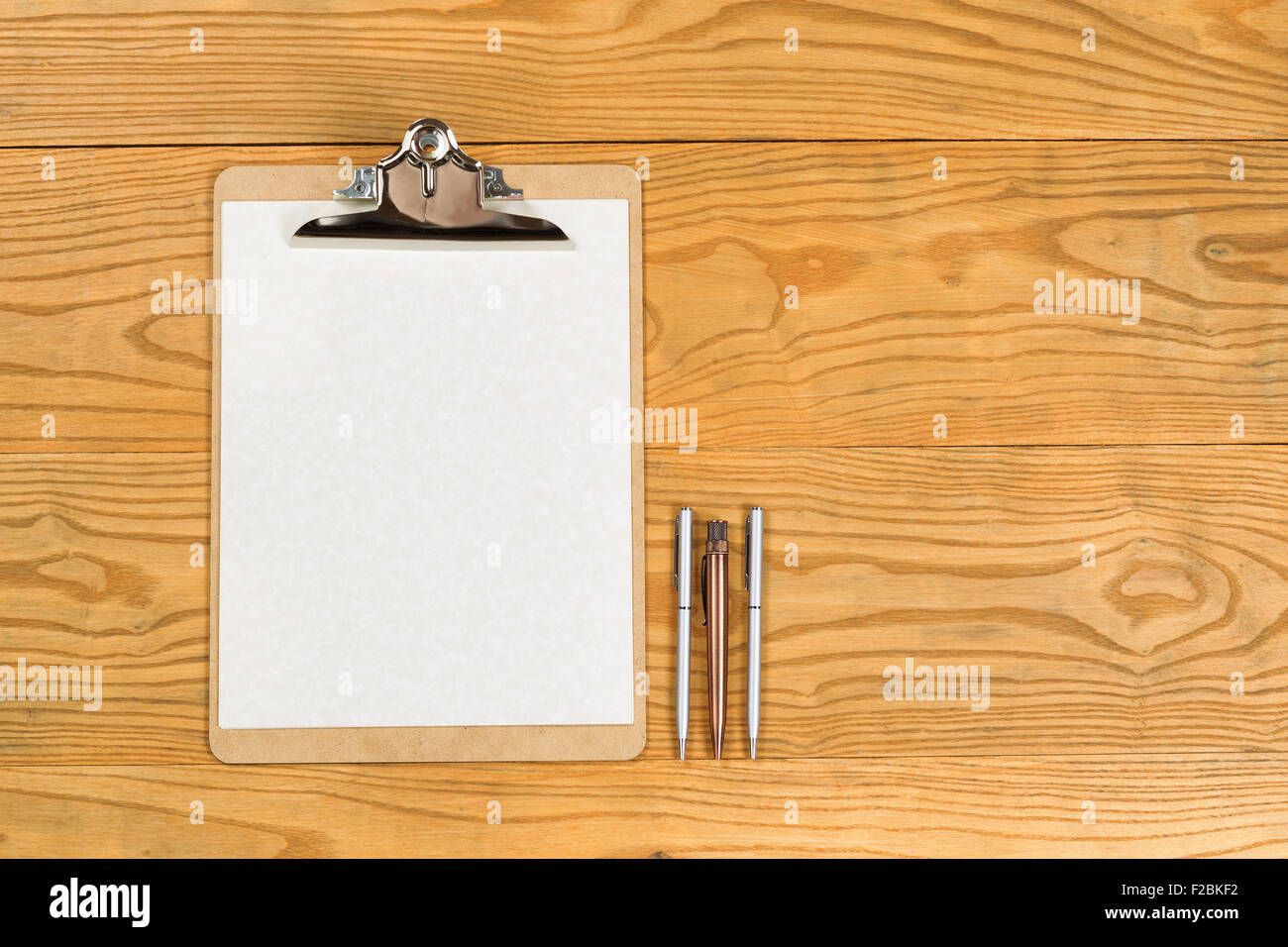 Vue de dessus du presse-papiers traditionnels, papier blanc, et des stylos en bois sur le bureau. Banque D'Images