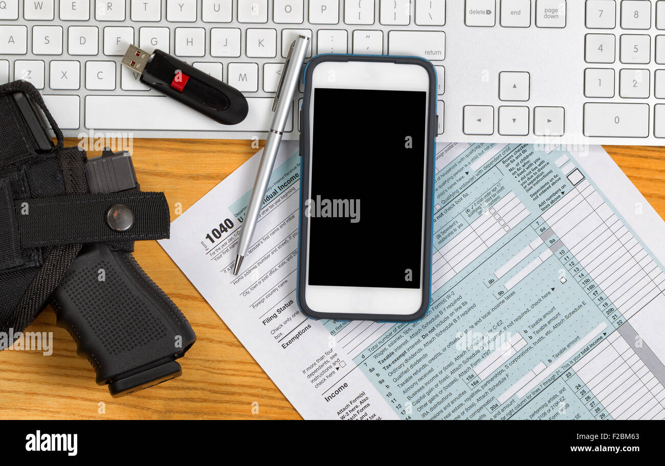 Vue de dessus de l'arme de service, clavier, stylo, clé usb et IRS Formulaire d'impôt sur le bureau. Concept de vérification. Banque D'Images