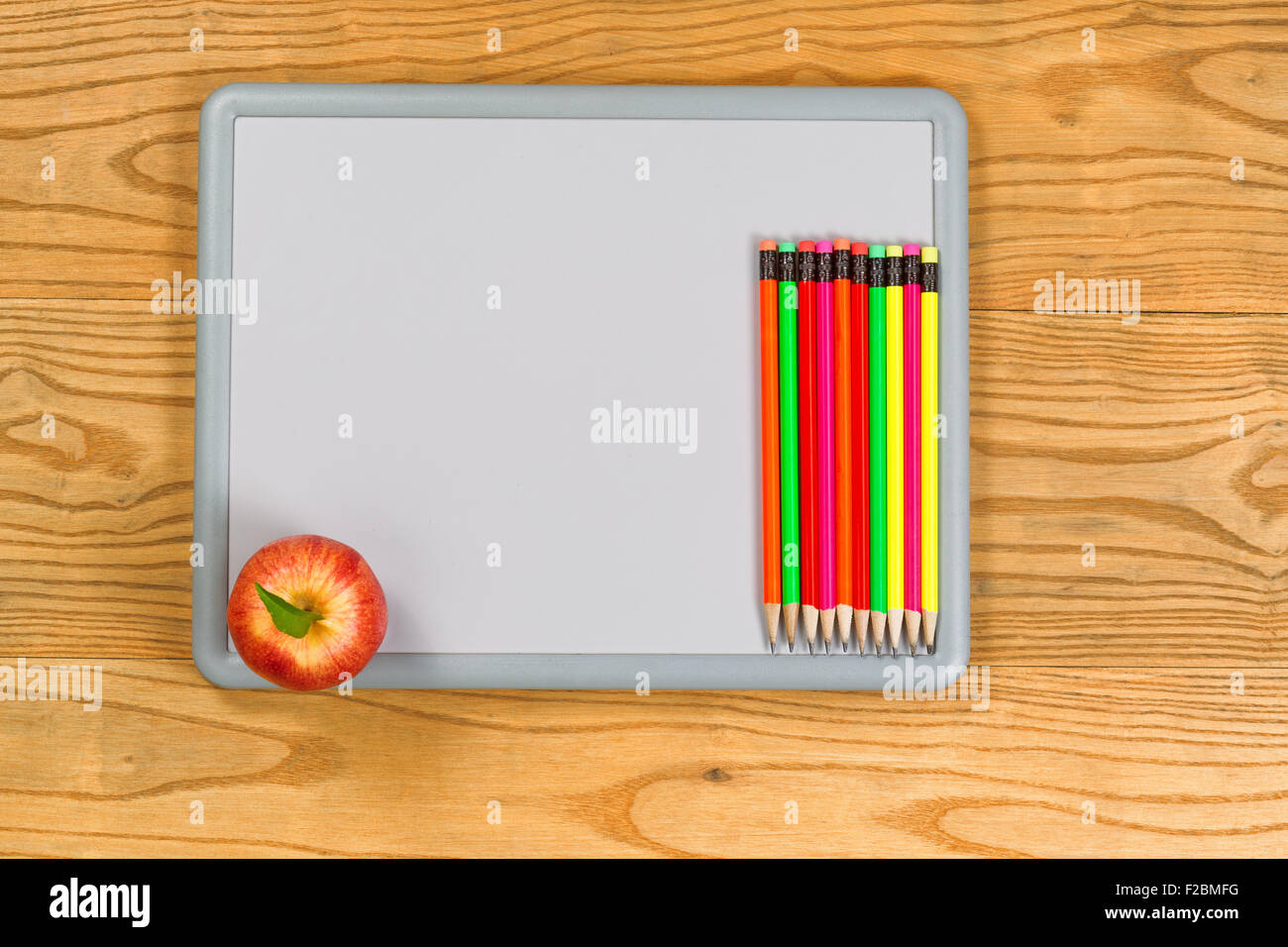 Vue de dessus de crayons colorés et Apple sur un tableau blanc. Concept Retour à l'école. Banque D'Images