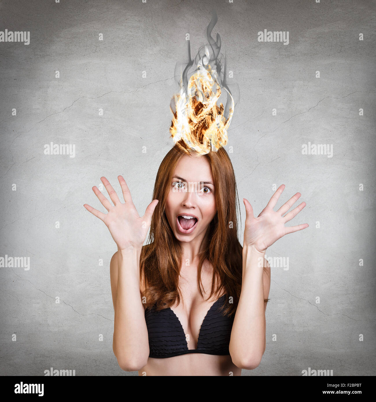 Femme qui a son cerveau en feu à cause du stress sur un fond gris Banque D'Images