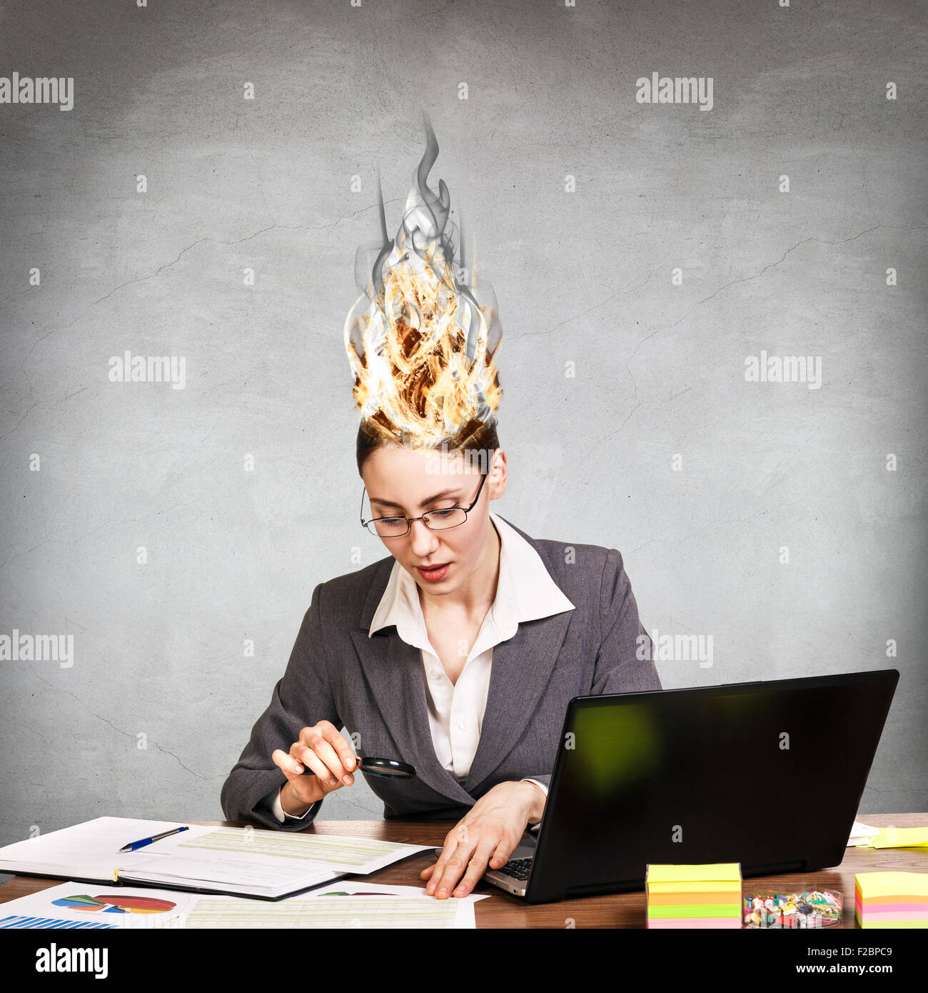 Femme qui a son cerveau en feu à cause du stress sur un fond gris Banque D'Images