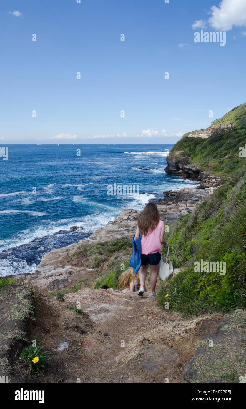 Trois adolescentes et des mains vers le bas de la tête de falaise Turimetta beach Warriewood au NSW Australie Banque D'Images