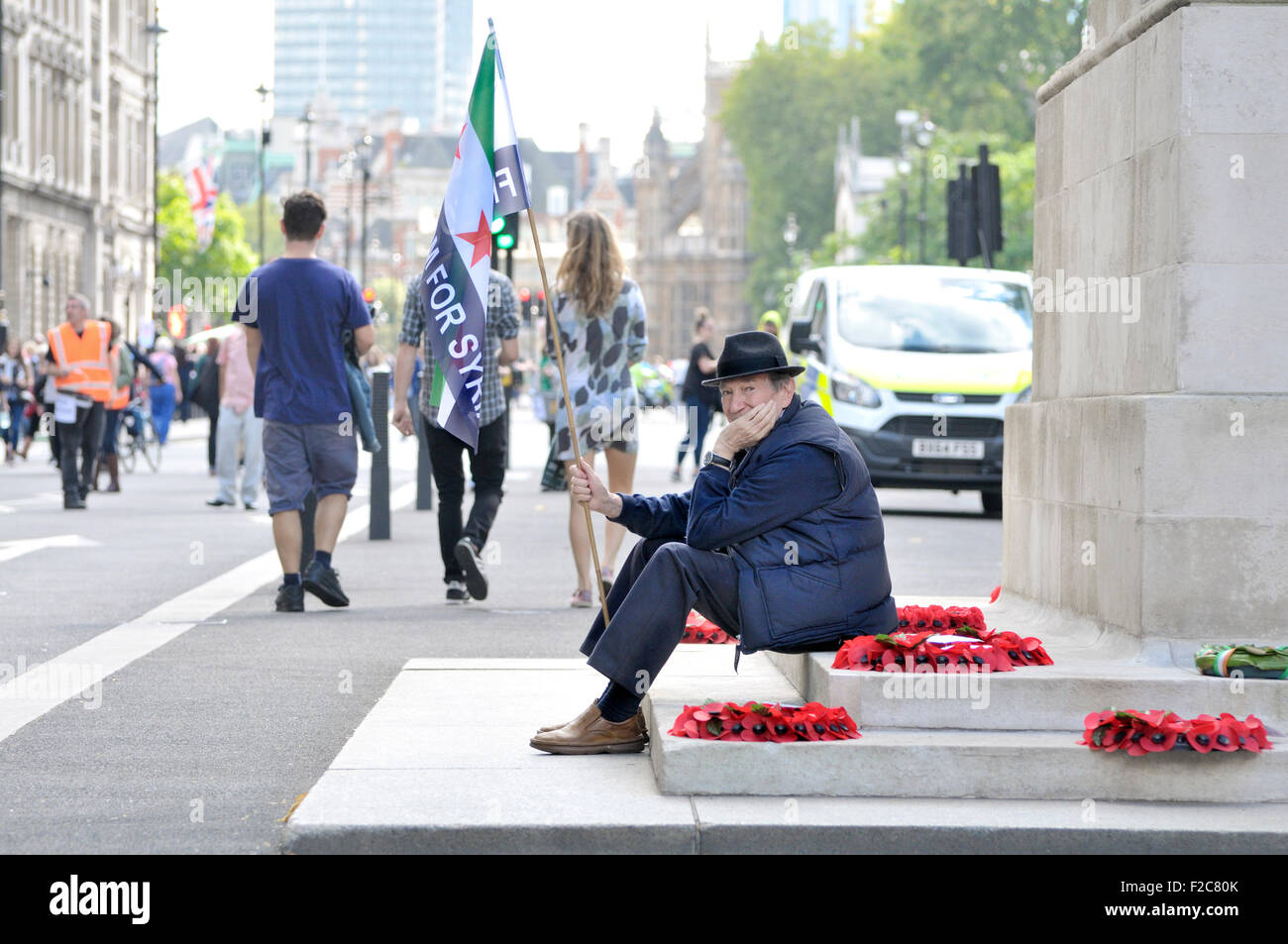 12 Sept 2015 de Londres. Homme assis au cénotaphe de Whitehall avec une "Liberté pour la Syrie' flag. 'Réfugiés Bienvenue ici", Banque D'Images