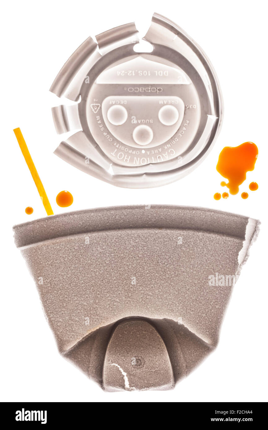 Tasse à café en styromousse aplaties à l'aide ci-dessus et bâtonnet jaune sur la table lumineuse avec des gouttes de café Banque D'Images