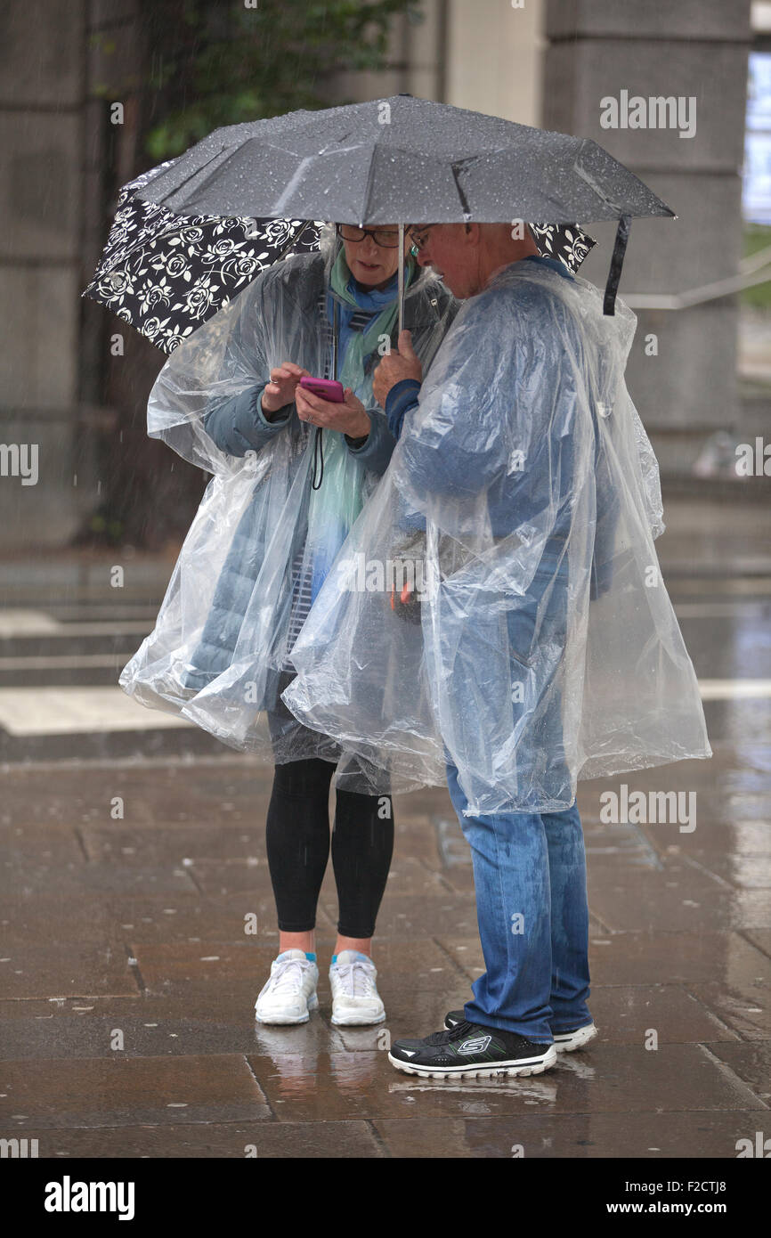 Londres, Royaume-Uni. 16 Septembre, 2015. Les touristes prendre des précautions contre le mauvais temps dans le West End à Londres sous une pluie torrentielle sur la journée qu'un avertissement jaune pour la pluie n'a été émis par le Met Office en tant qu'ex-tempête tropicale se déplace de l'Atlantique. Crédit : Jeff Gilbert/Alamy Live News Banque D'Images