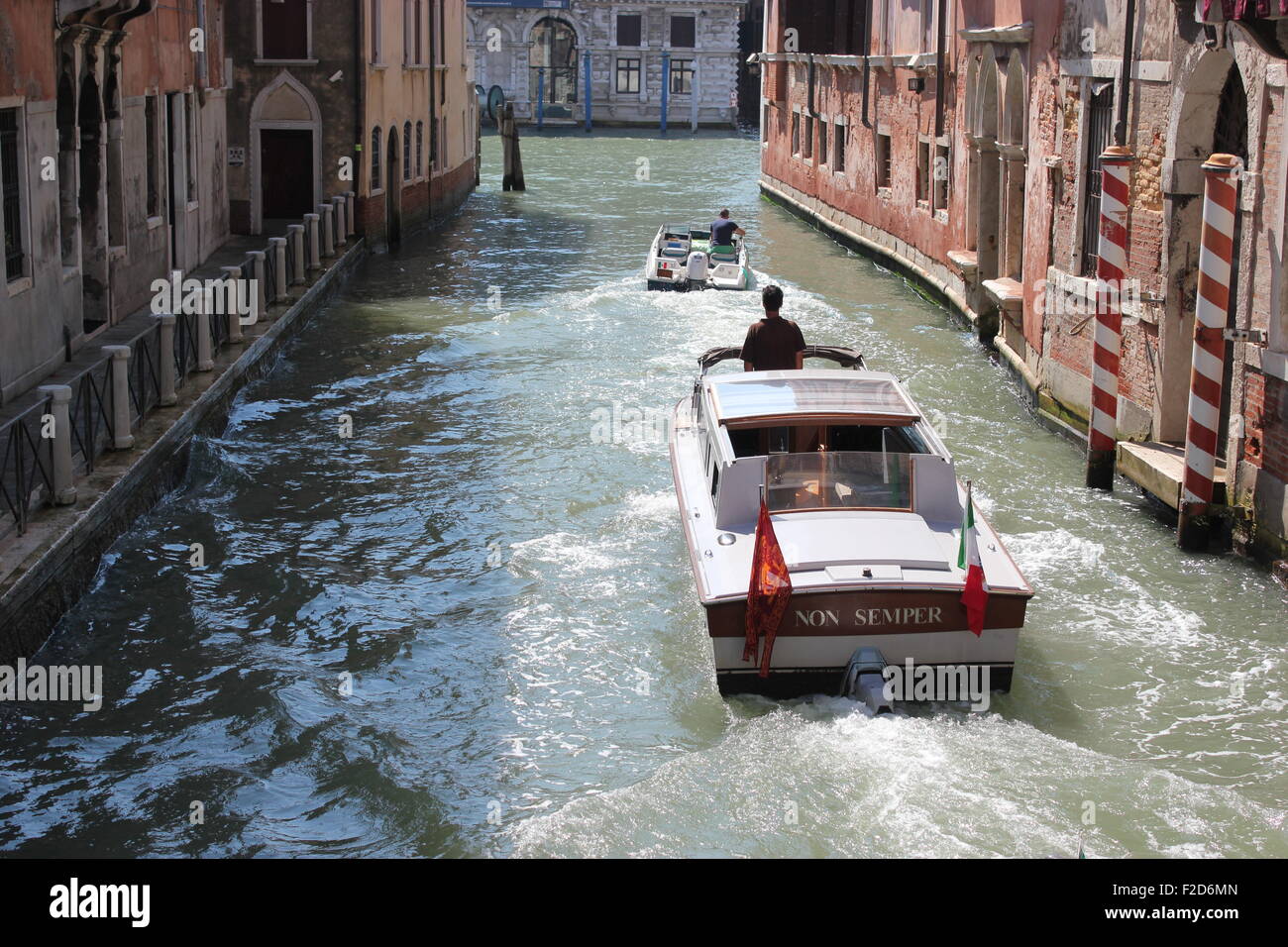 Vitesse de deux bateaux le long des canaux de Venise Banque D'Images