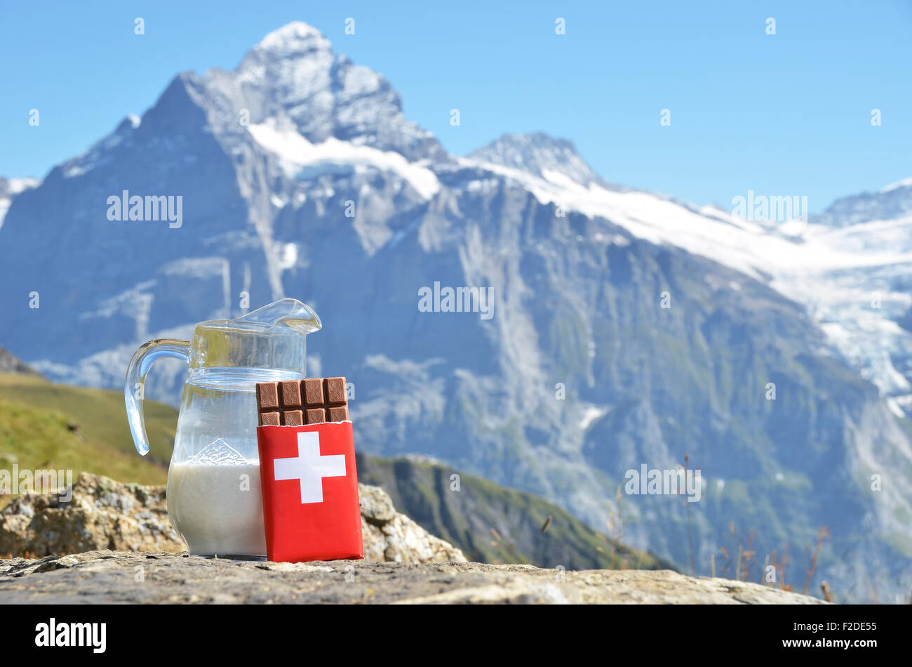 Le chocolat suisse et verseuse de lait contre sommet de montagne. La Suisse Banque D'Images