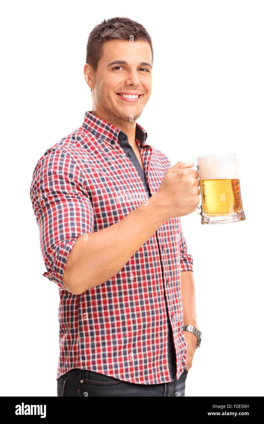 D'un coup vertical cheerful young man holding a beer mug plein de bière et smiling isolé sur fond blanc Banque D'Images