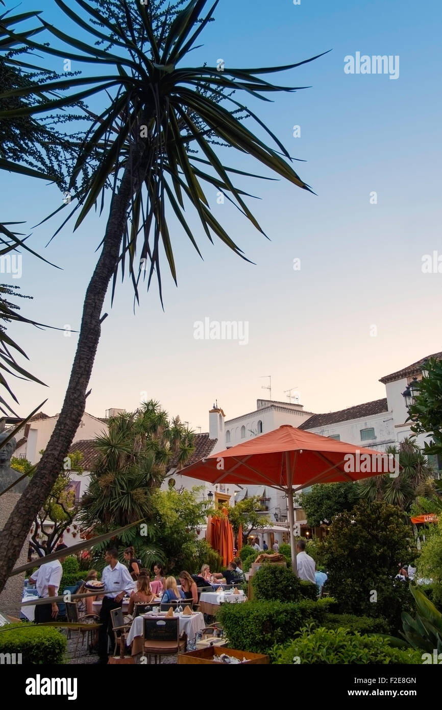 Les gens de manger en plein air dans le style carré orange, vieille ville de Marbella, Espagne. Banque D'Images