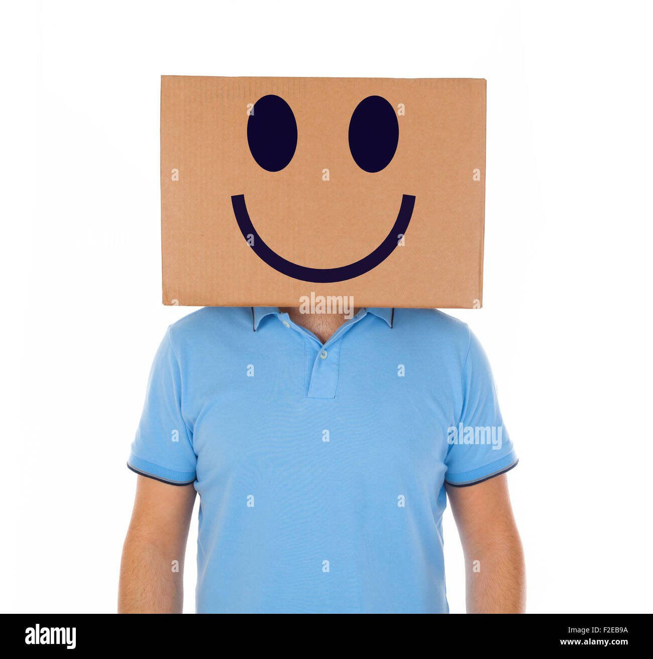 Jeune homme debout avec une boîte en carton sur la tête avec des smiley sur fond blanc. Banque D'Images