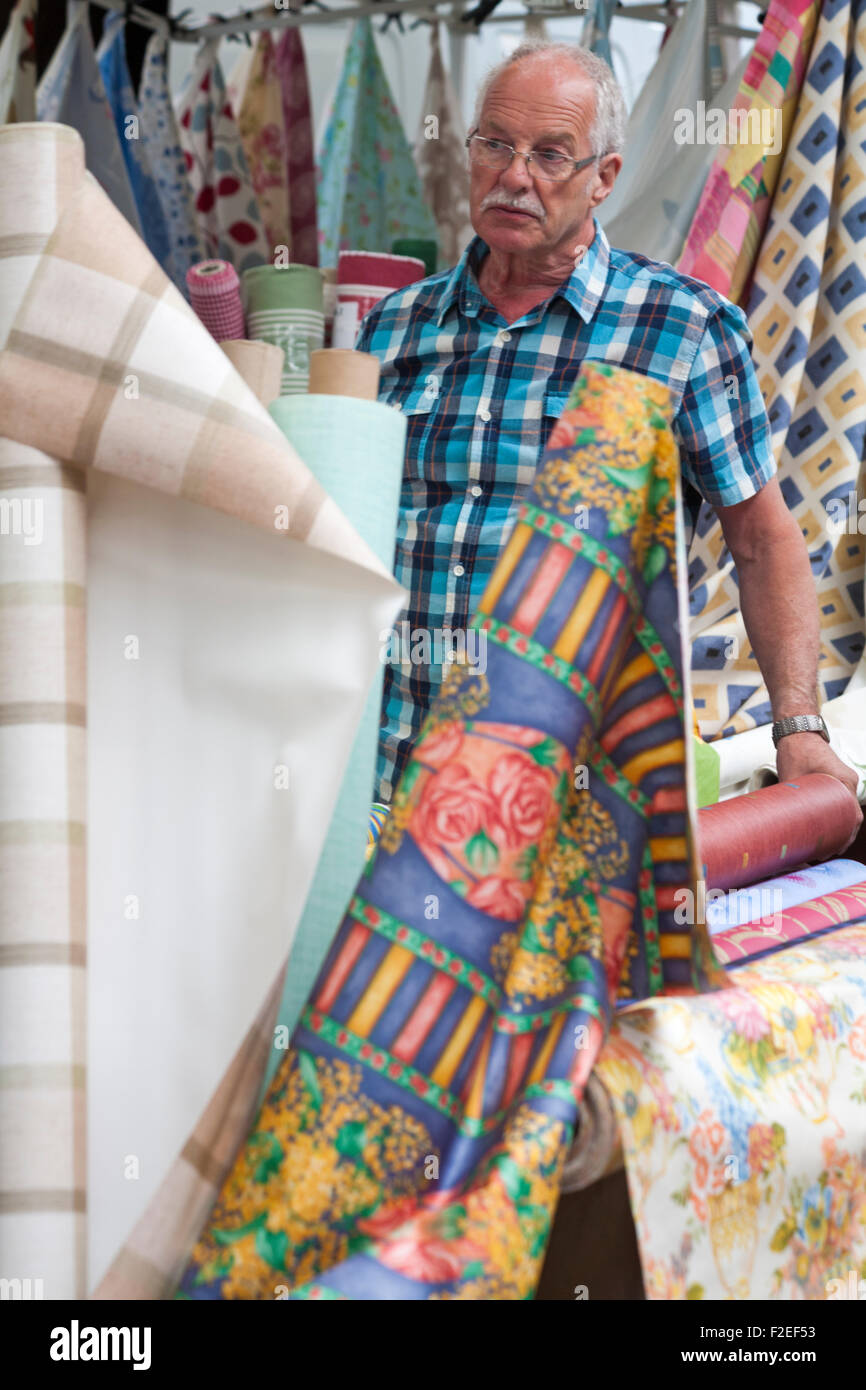 Support de décrochage avec rouleaux colorés de tissu à vendre sur le marché de la stalle à Dorchester, Dorset, Royaume-Uni en juin Banque D'Images