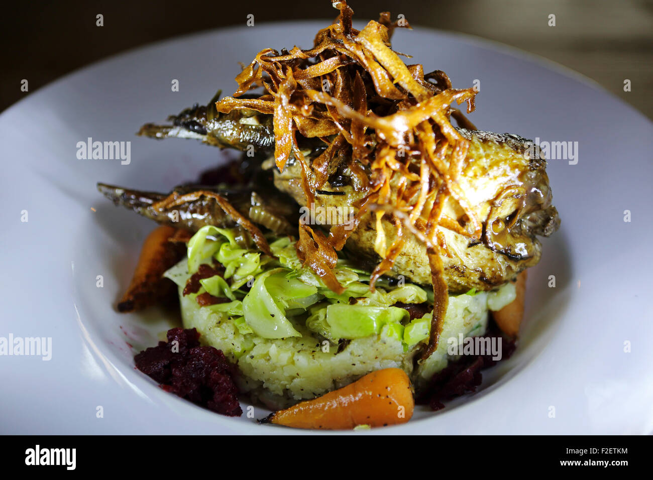 Perdrix rôties Pot servi avec des chips de panais, chou de Savoie et écrasée de pommes de colcannon. Banque D'Images