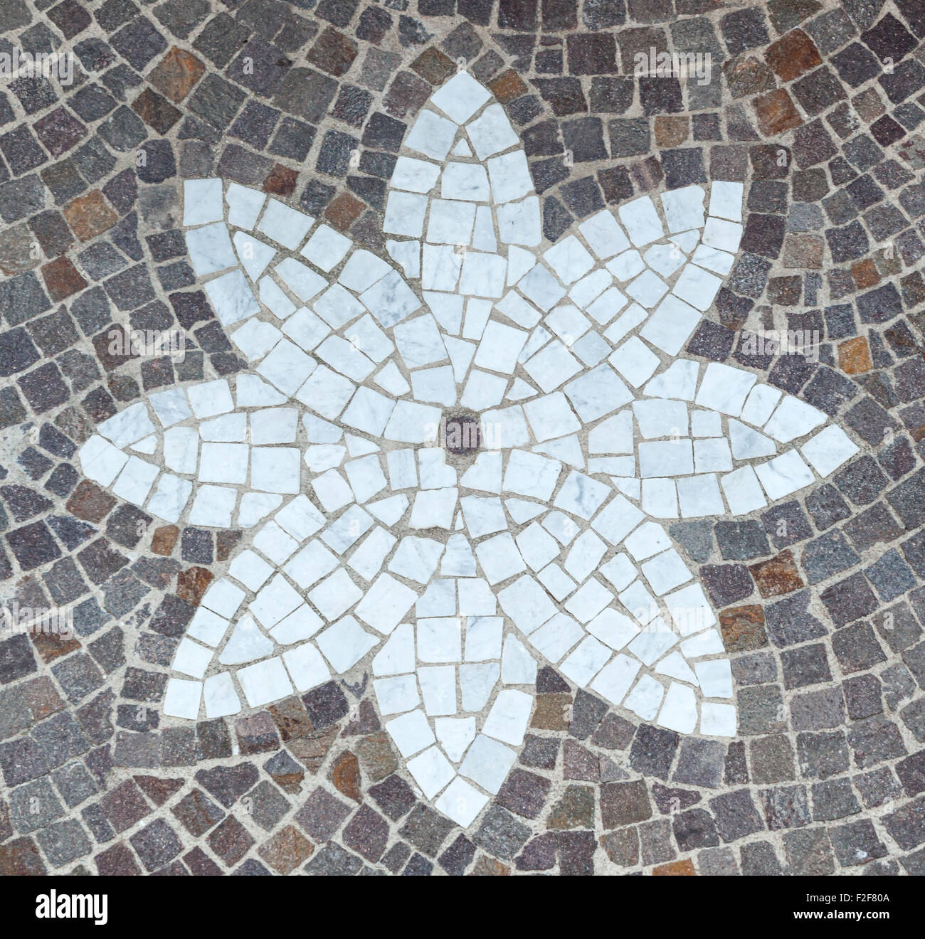 Le pavage de galets pierres et design en forme de fleur faite avec des cubes de marbre. Banque D'Images