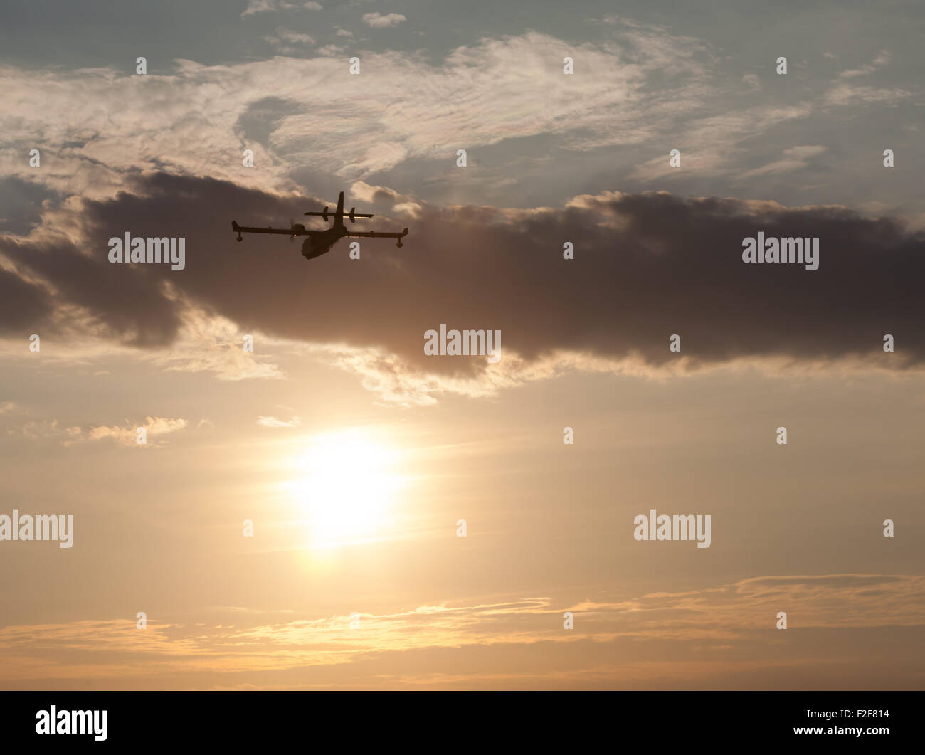 Silhouette d'un avion au coucher du soleil dans les nuages Banque D'Images