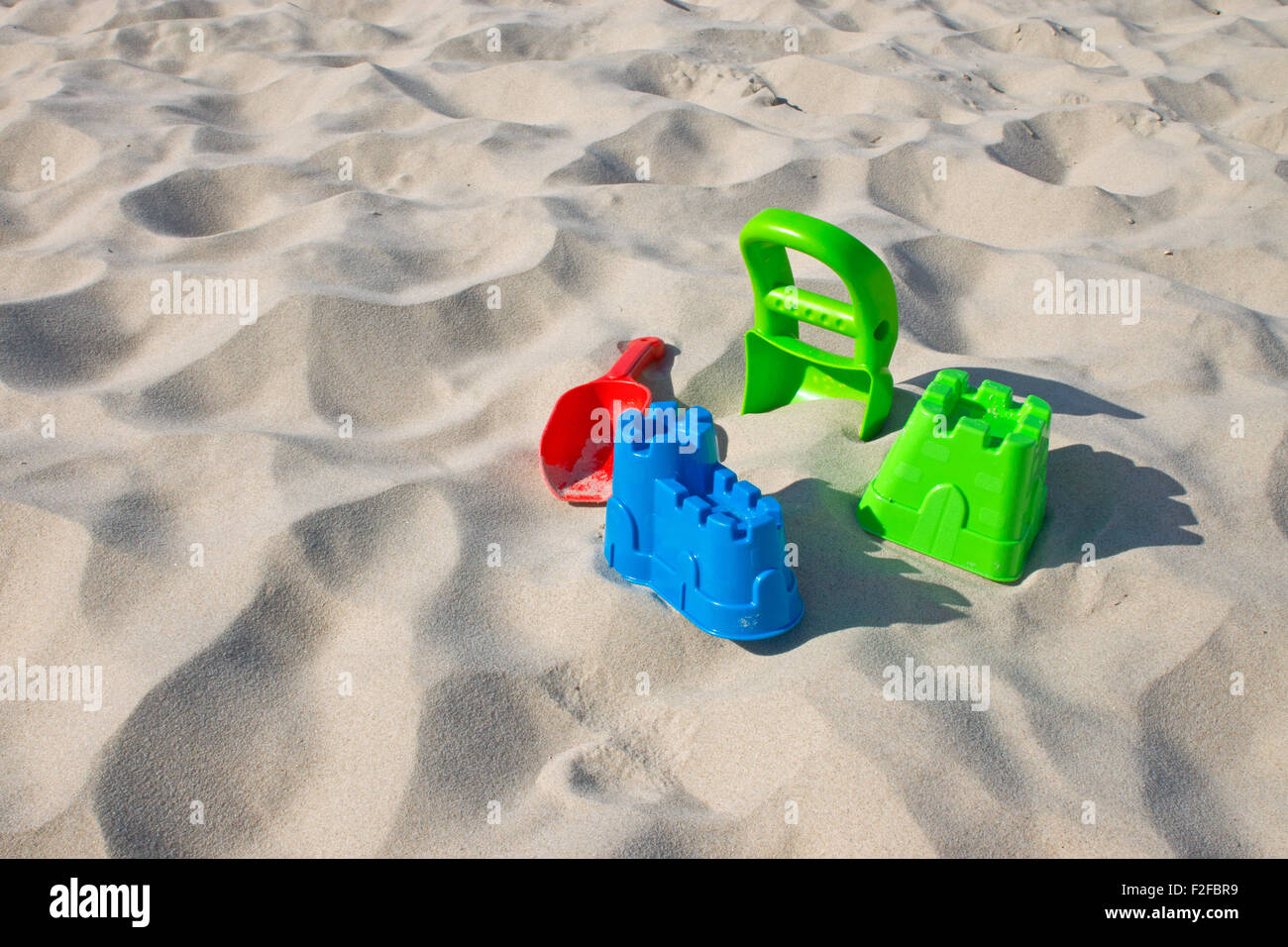 Les jouets colorés portant dans le sable d'une plage Banque D'Images