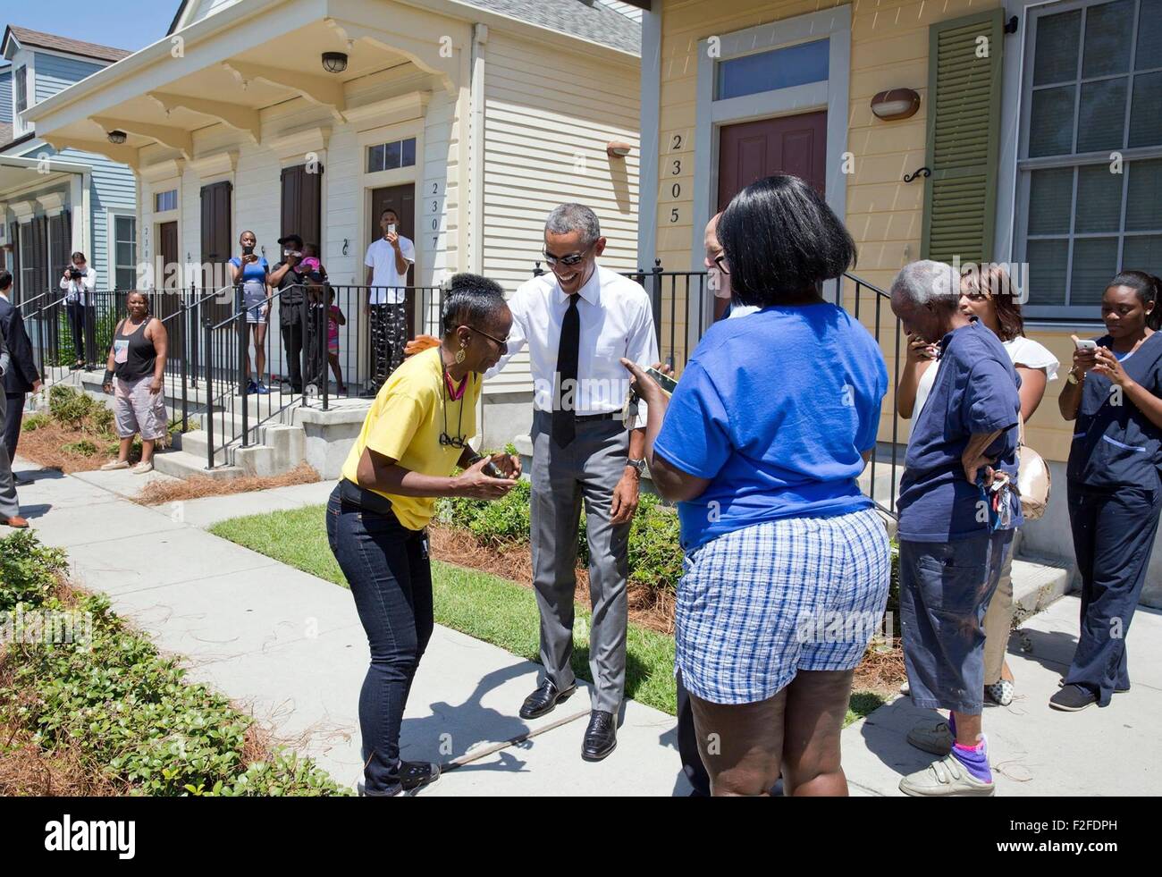 Le président des États-Unis, Barack Obama, des blagues avec les résidents devant leurs maisons pendant une promenade à travers le quartier de Treme Maire Mitch Landrieu, 27 août 2015 à la Nouvelle Orléans, Louisiane. Le président est en visite à New Orleans pour marquer le dixième anniversaire de l'ouragan Katrina. Banque D'Images