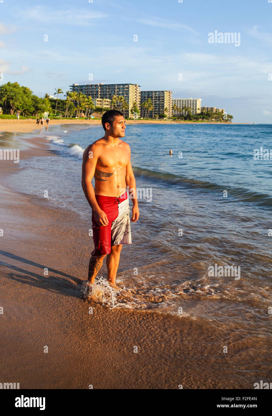 Homme à la plage de Kaanapali sur Maui près de Black Rock au coucher du soleil Banque D'Images