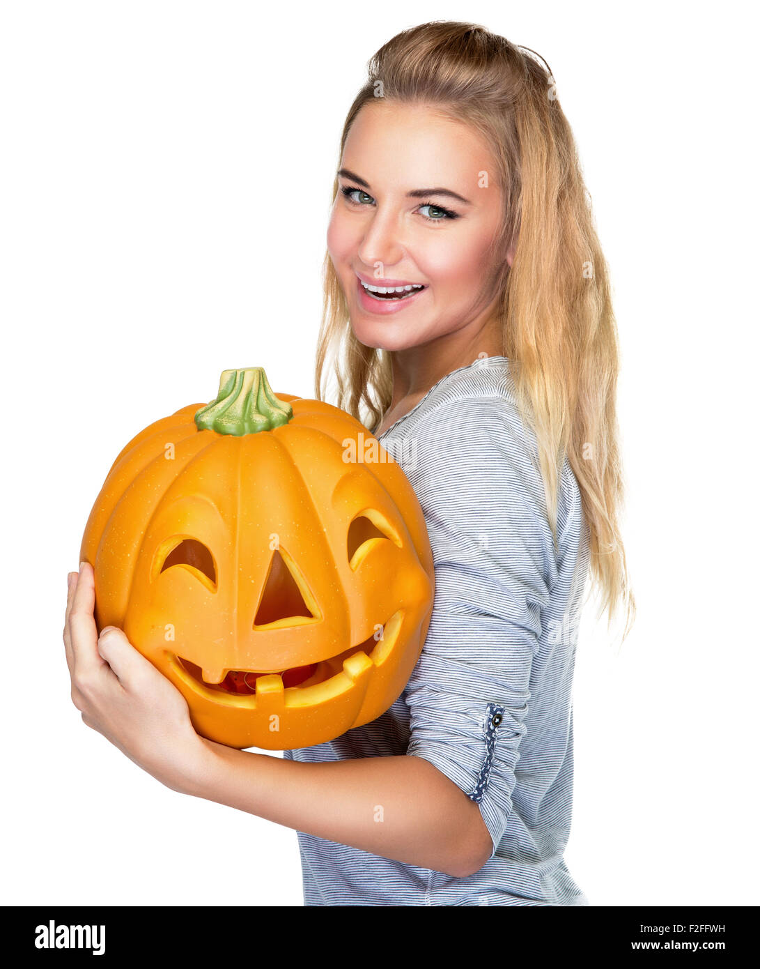 Portrait de la belle blonde à la tenue en mains au visage sculpté de citrouille isolé sur fond blanc, happy Halloween Banque D'Images