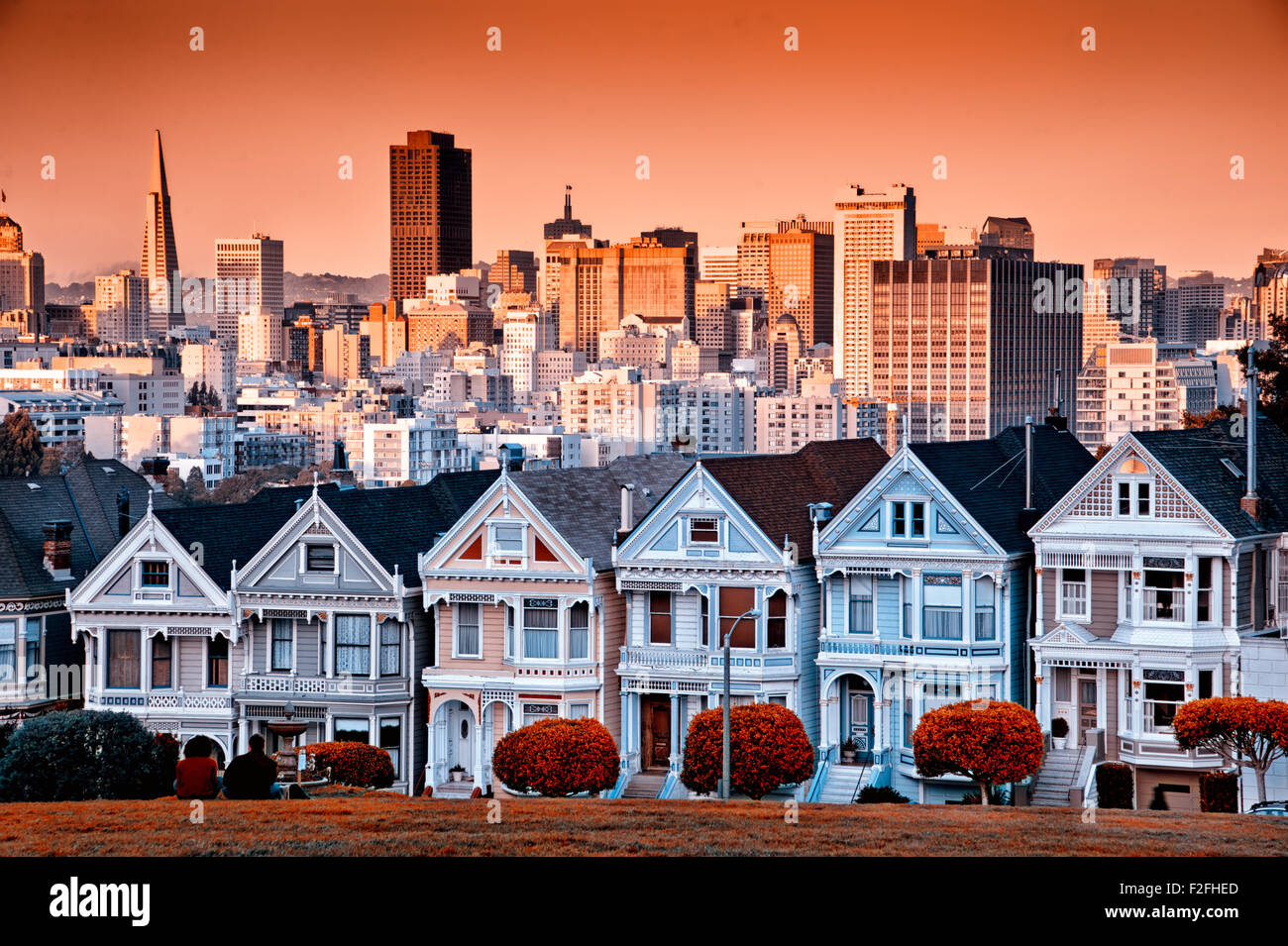 Rangée de maisons victoriennes colorées sur Steiner Street avec l'horizon de San Francisco derrière. Banque D'Images