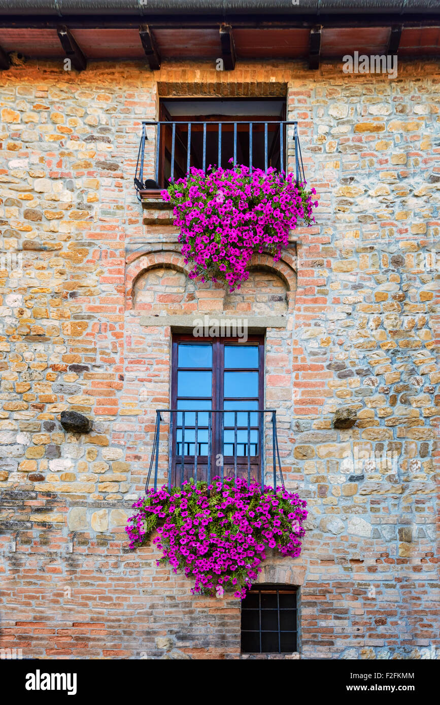 Vintage magnifique balcon avec des fleurs colorées et mur de pierre médiévale , style Méditerranéen Banque D'Images