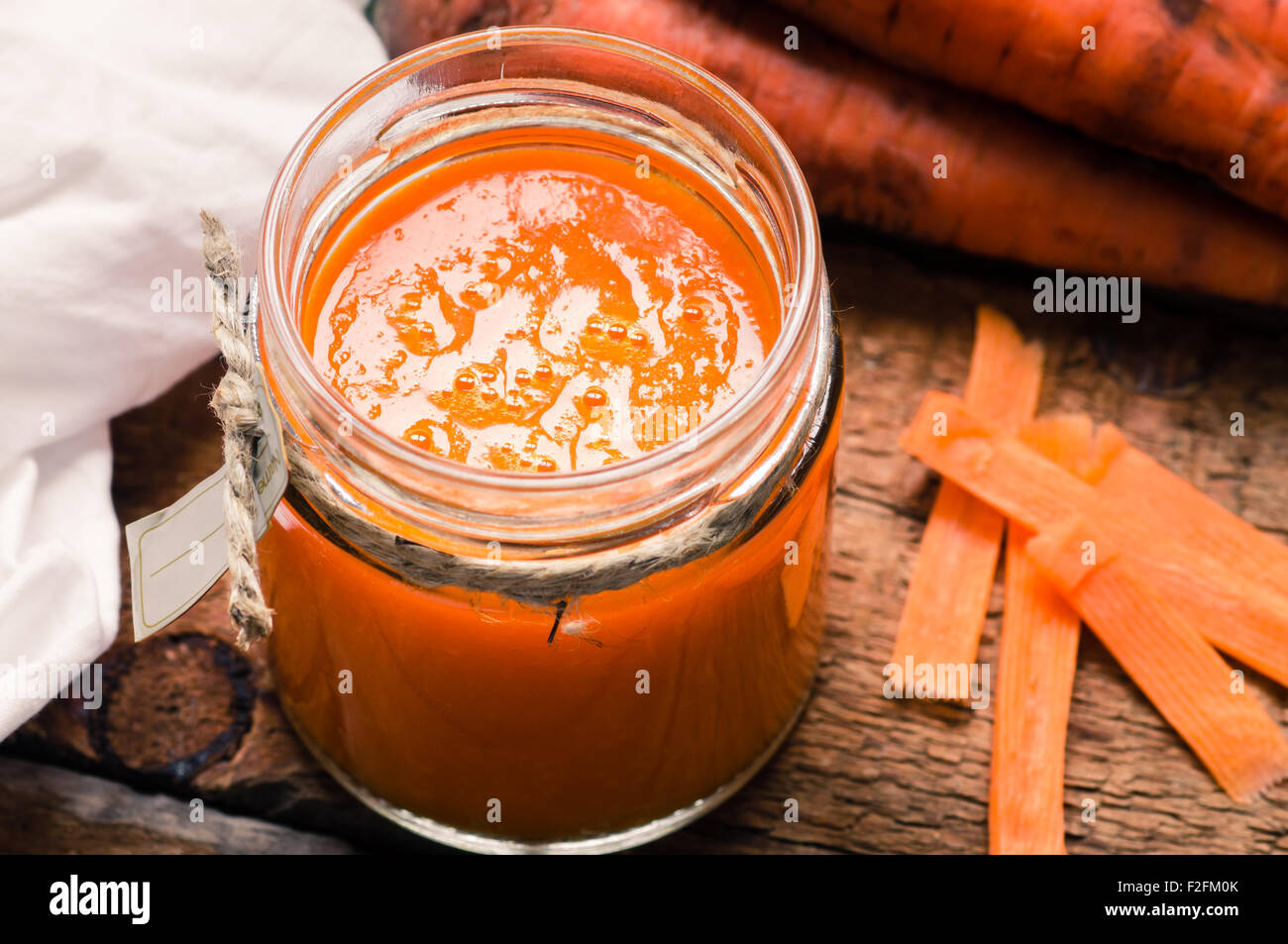 Smoothie carotte dans un bocal en verre sur la table en bois Banque D'Images