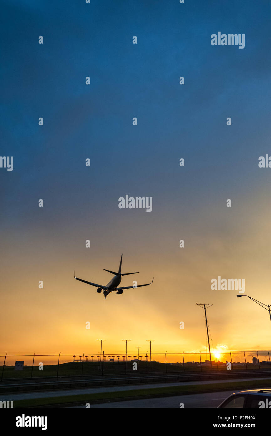 Jet de Delta Airlines à l'atterrissage à l'Aéroport International d'Atlanta contre la brillante lumière d'un ciel coucher de soleil vif. (USA) Banque D'Images