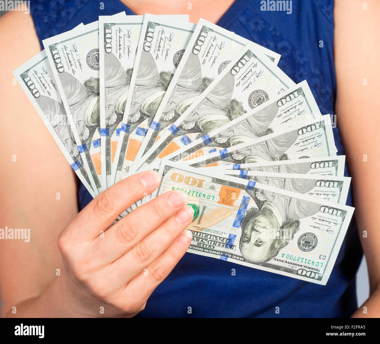 La femme en bleu Dress Holding Nouvelle 100 US Dollar Bills Banque D'Images