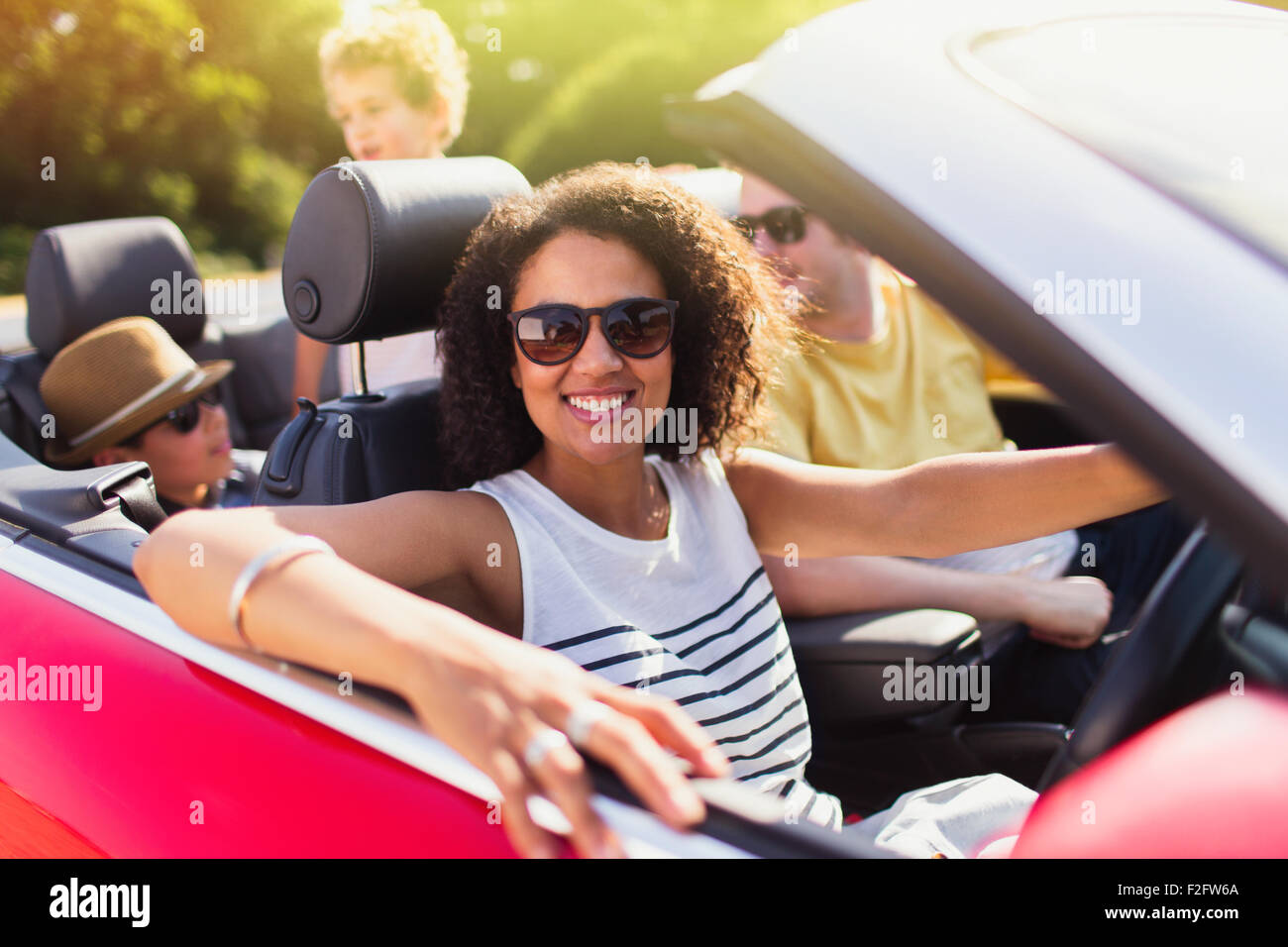 Portrait femme enthousiaste driving convertible en famille Banque D'Images