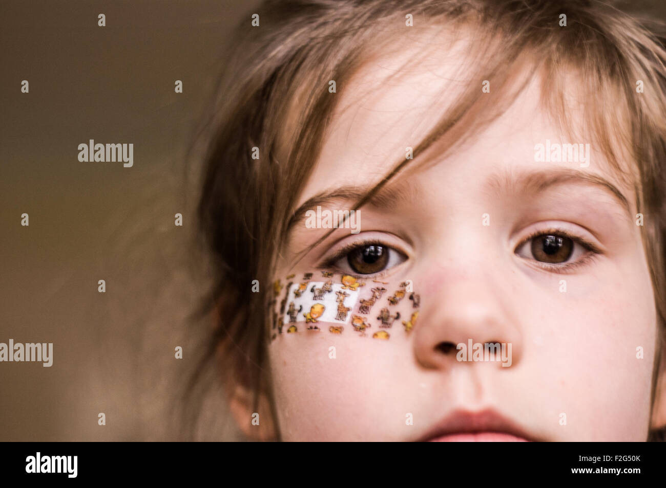 Un regard intense d'une belle jeune fille avec un plâtre sur son visage  Photo Stock - Alamy