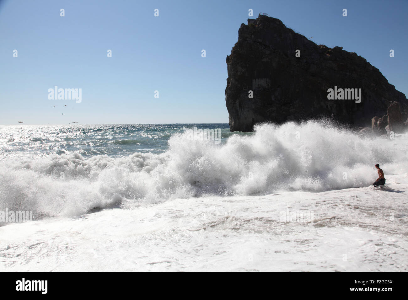 Une mer agitée à Simeiz, Crimée. Un touriste rare passe en ondes dangereuses.Diva rock est l'un des monuments plus célèbres de Crimée célèbre pour le plaisir d'été. Banque D'Images