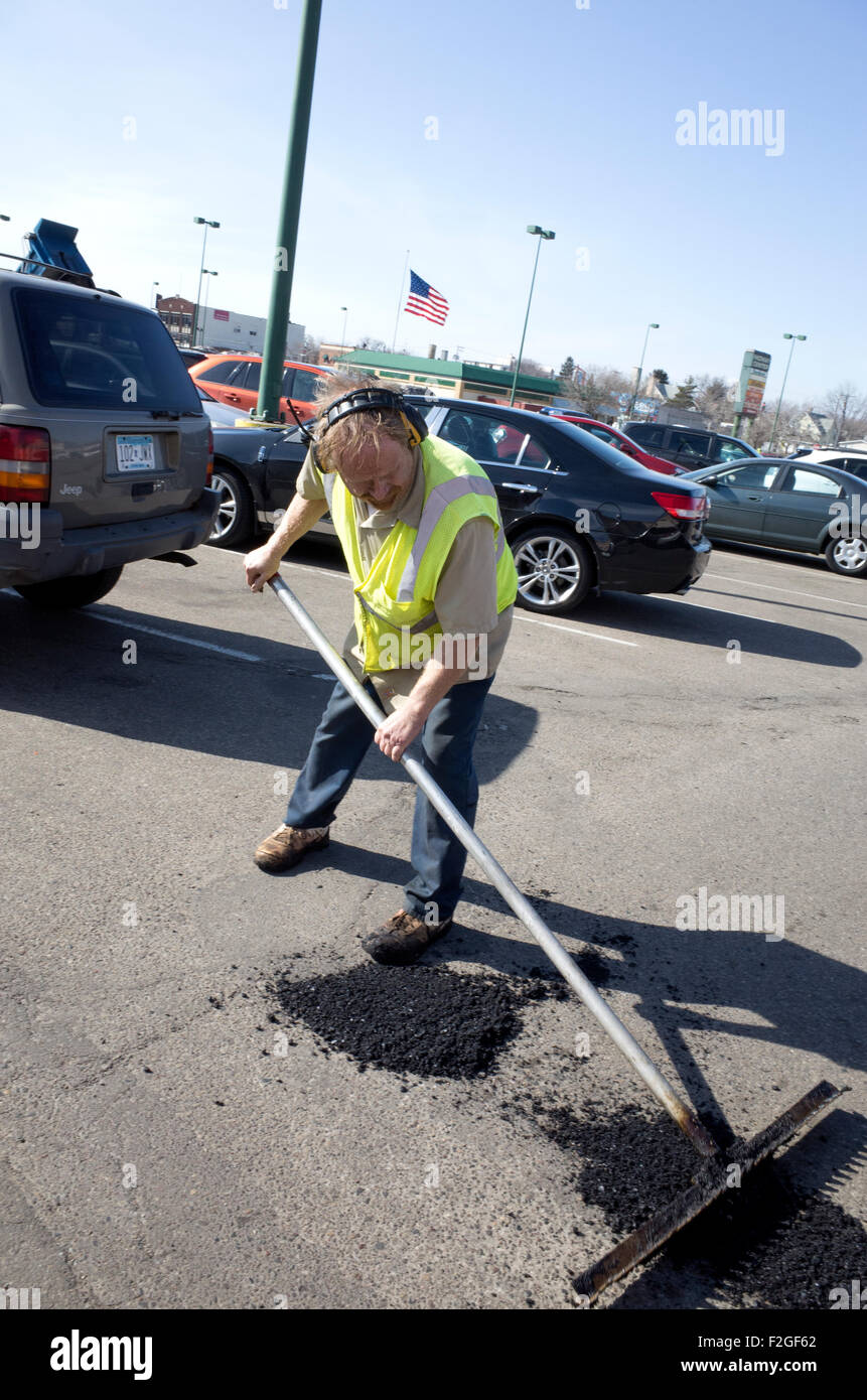 Homme d'entretien de l'asphalte sur lissage patched-de-poule dans city parking. St Paul Minnesota MN USA Banque D'Images