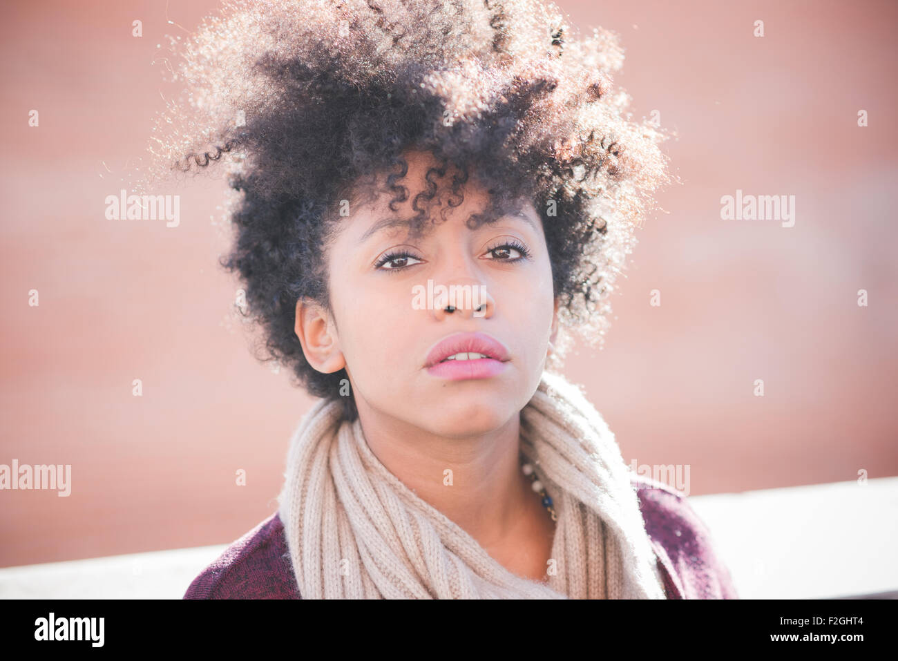 Portrait d'une belle jeune femme africaine cheveux noirs frisés en ville à la recherche d'appareil photo, pensive - jeunes, pensive, concept graves Banque D'Images