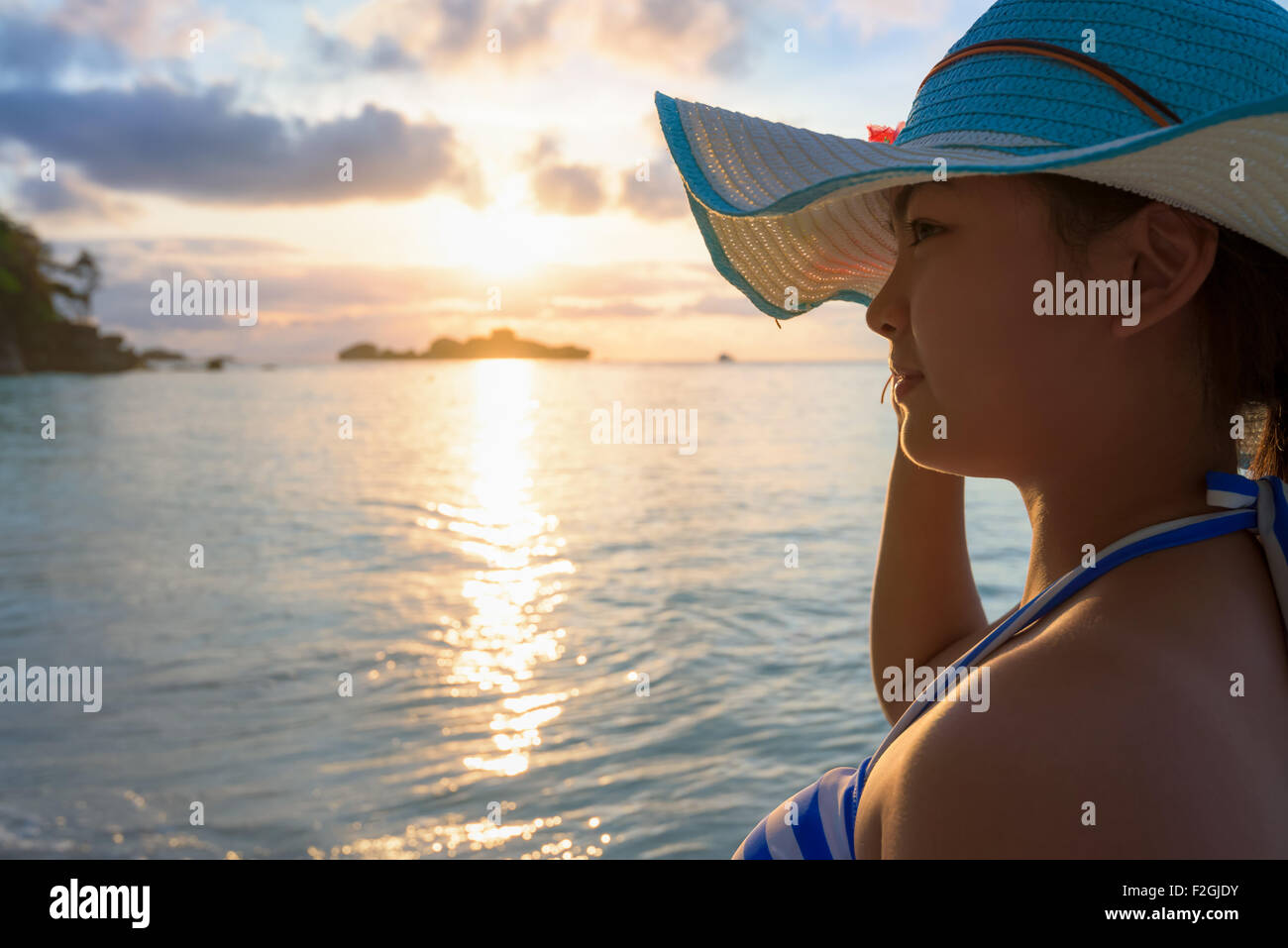 Fille avec maillot rayé bleu et blanc l'article watch nature ciel et mer pendant le lever du soleil sur la plage de Honeymoon Bay à Koh Banque D'Images
