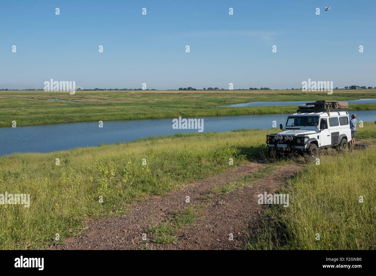 Land Rover parqué par une rivière sur un chemin de terre au Botswana, l'Afrique Banque D'Images