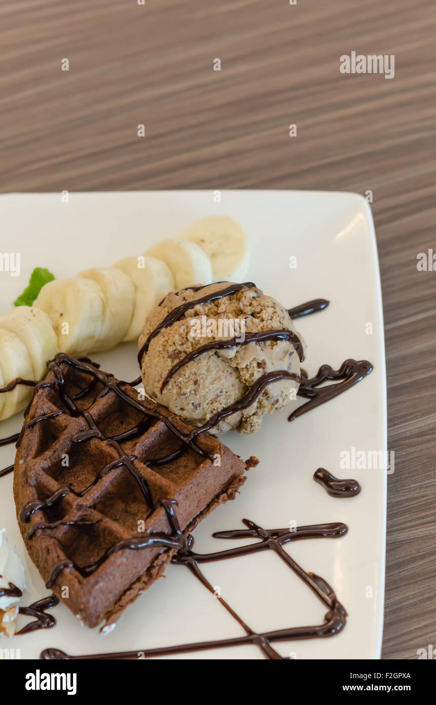 Crème glacée , banane , gaufres au chocolat avec sauce au chocolat et crème fouettée Banque D'Images