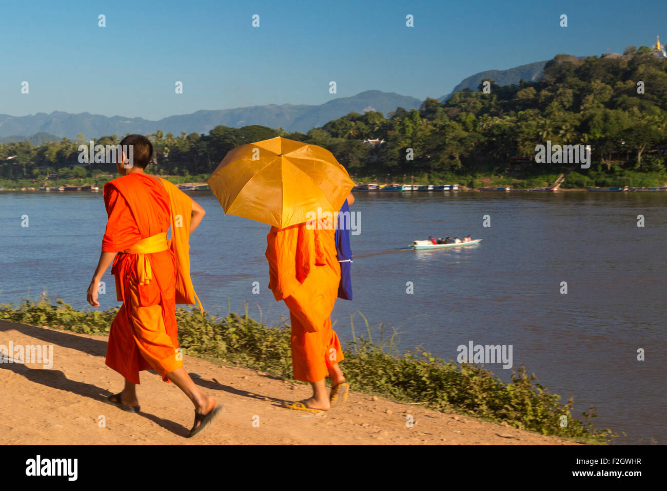 Moines avec parasol sur les rives du Mékong, Luang Prabang, Laos Banque D'Images