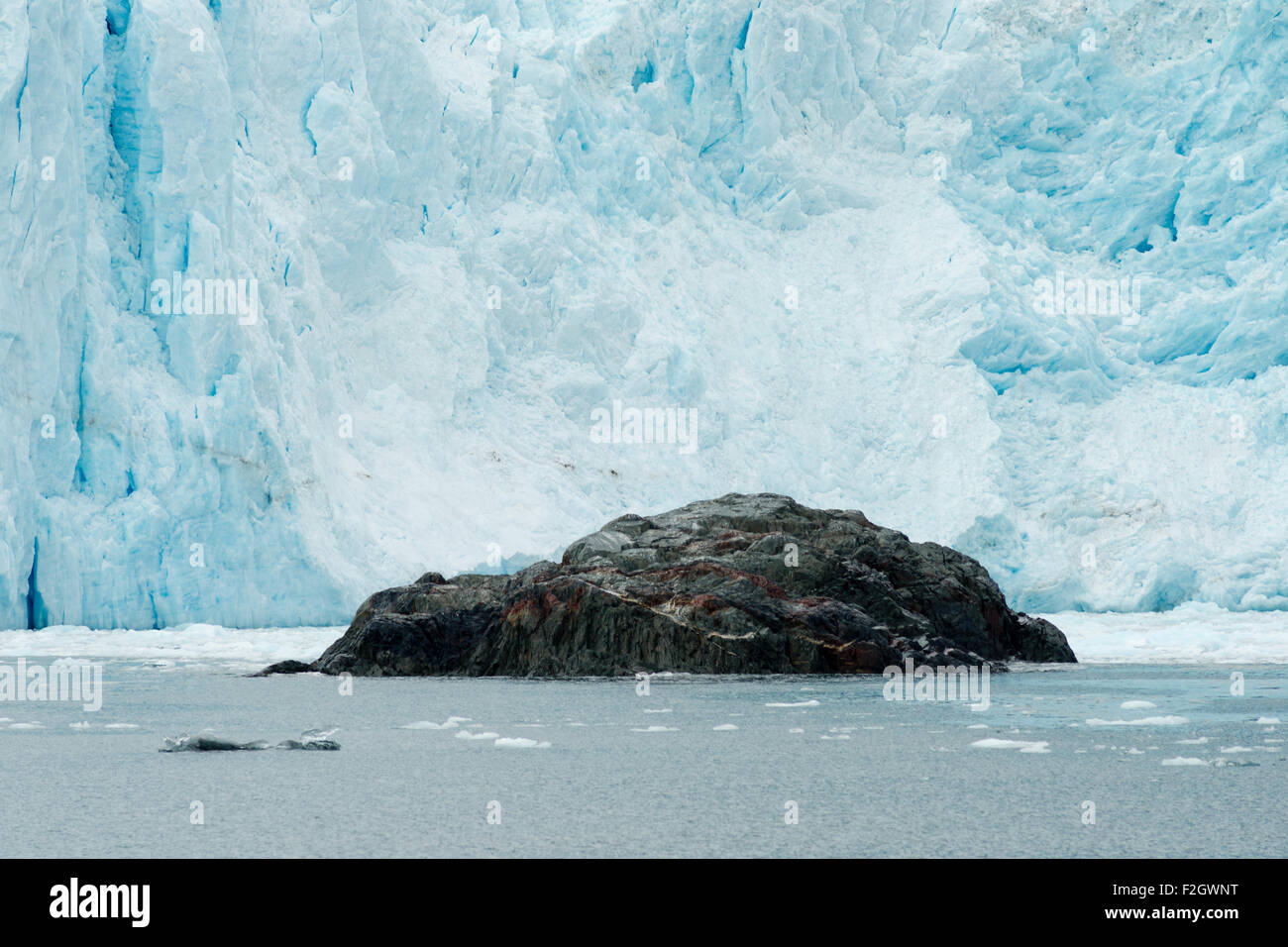 Un grand affleurement rocheux se trouve en face d'un glacier de mise bas Banque D'Images