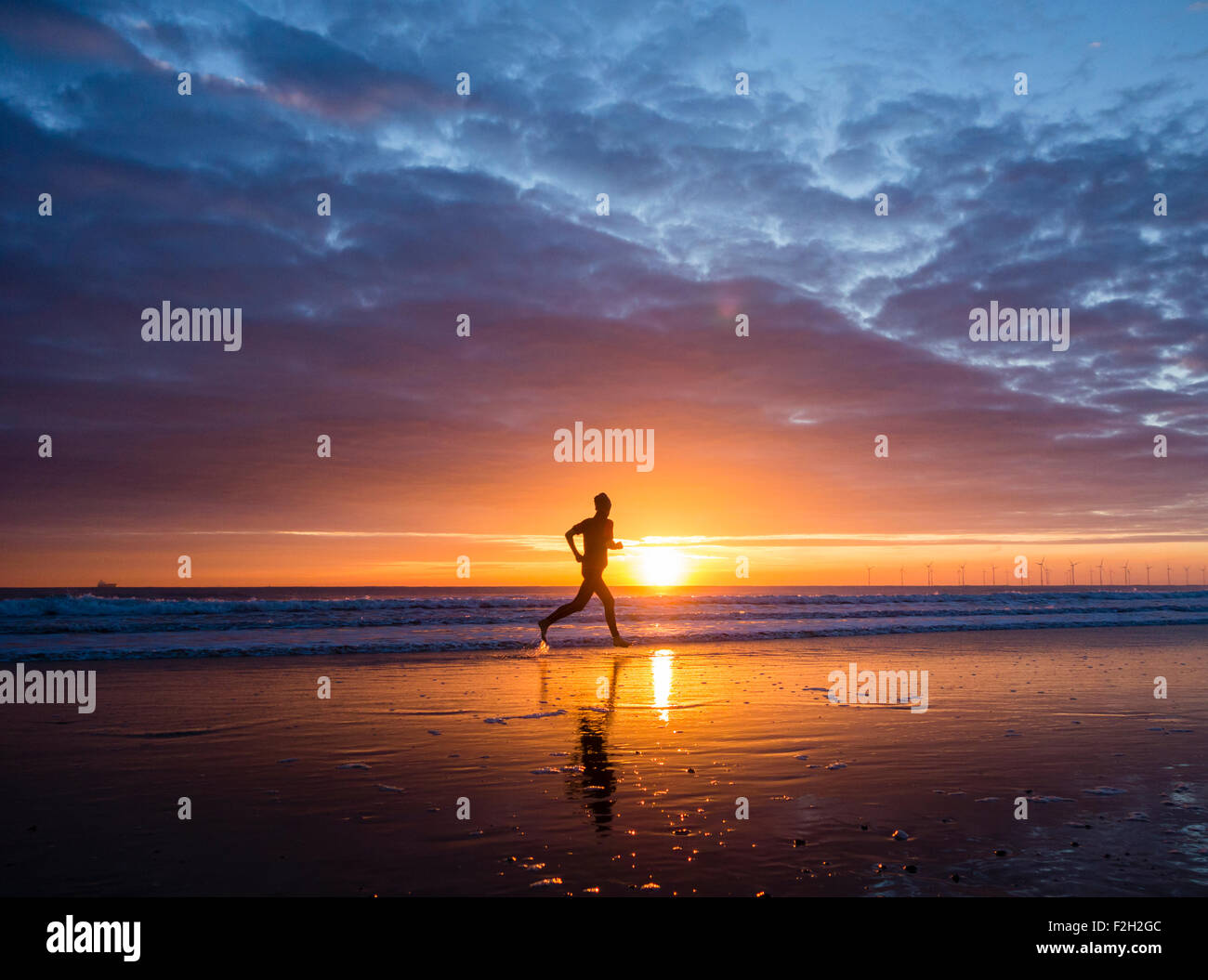 Seaton Carew, UK. 19 Septembre, 2015. Météo : jogger au lever du soleil sur la plage de Seaton Carew sur un glorieux samedi matin sur la côte nord-est de l'Angleterre. Avec haute pression sur le Royaume-Uni, le samedi est appelée à être ensoleillé avec des températures dans le milieu à des adolescents pour une grande partie de l'UK. Credit : Alan Dawson News/Alamy Live News Banque D'Images